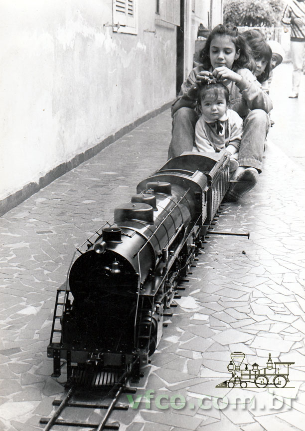 A locomotiva pronta para partir, levando a criançada, sobre os trilhos armados na garagem do ferreomodelista