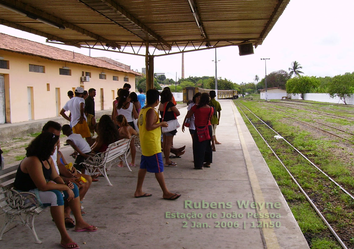 O trem que vai para Santa Rita volta de ré para entrar nos trilhos à esquerda da plataforma da estação ferroviária