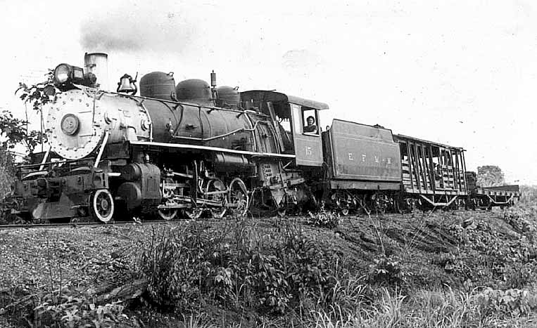 Locomotiva Mikado nº 15 em pleno trabalho, puxando um vagão gaiola e um prancha, no início de 1984