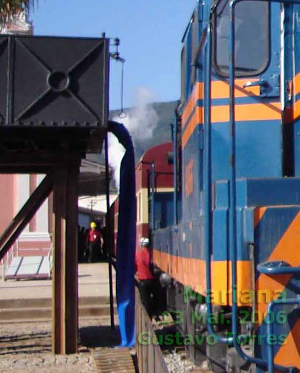 Locomotiva G8 parada diante da caixa d'água da estação ferroviária de Mariana