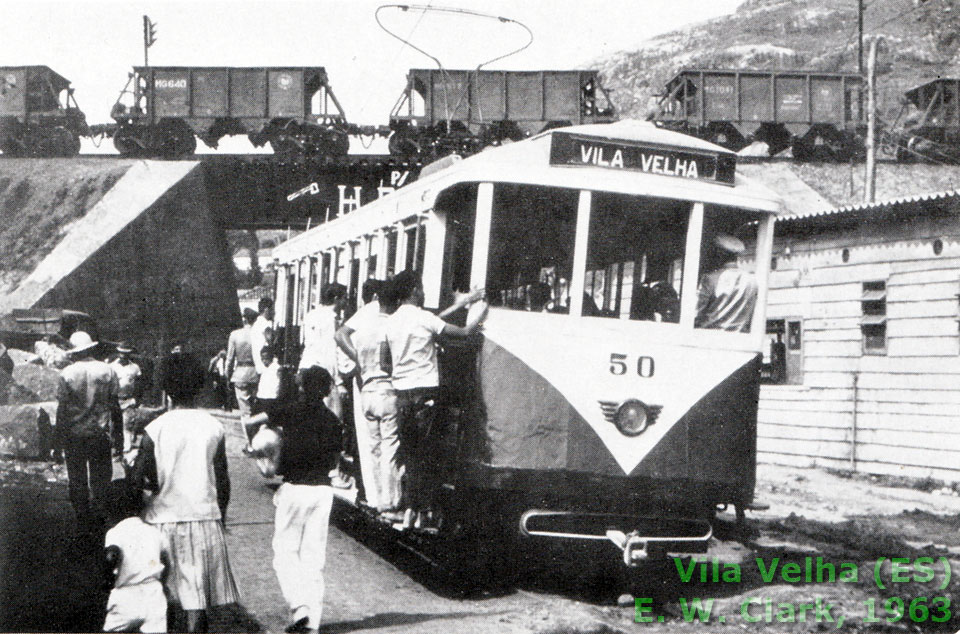 Bonde de Vila Velha (ES) em 1963, passando sob um trem de minério  da Leopoldina, segundo o autor, embora as gôndolas MG estampem o emblema da CVRD