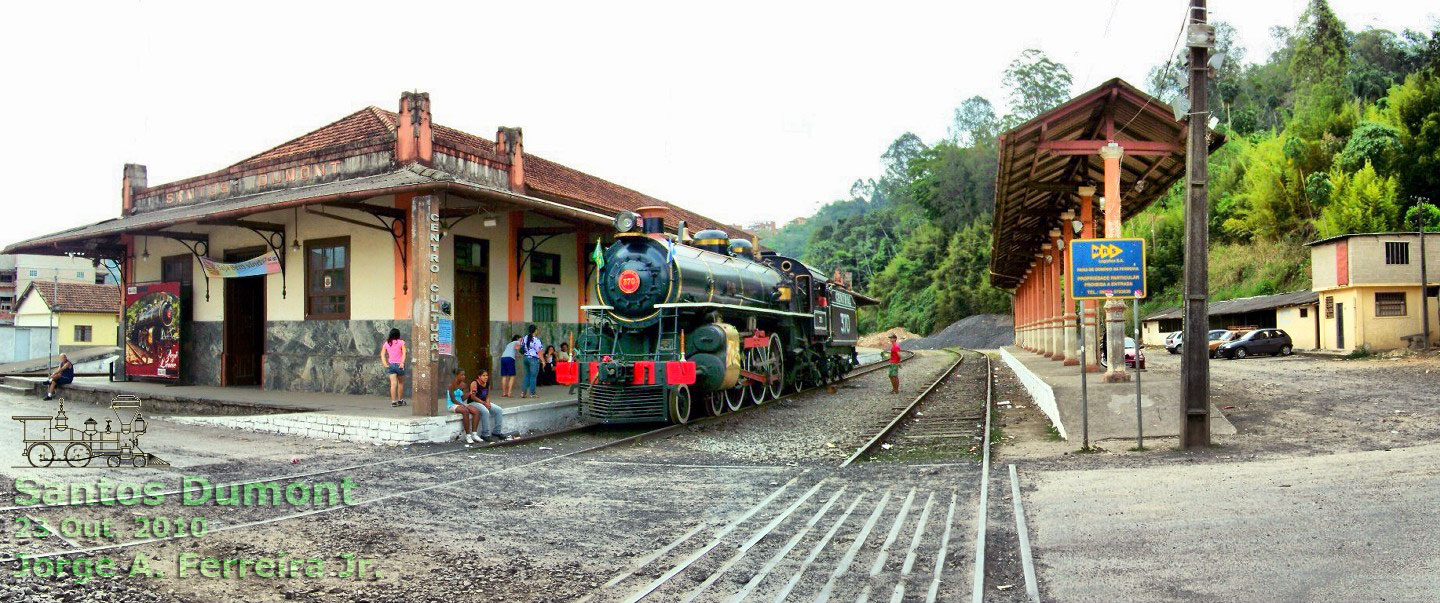 Vista panorâmica da estação ferroviária de Santos Dumont (MG), com a locomotiva Zezé Leone e o estribo, junto à passagem de nível