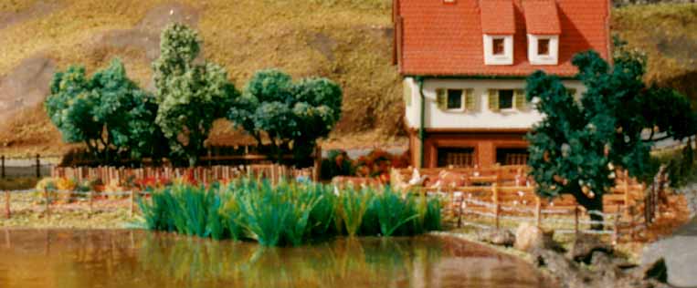 Paisagem da maquete, com os tufos de capim no lago