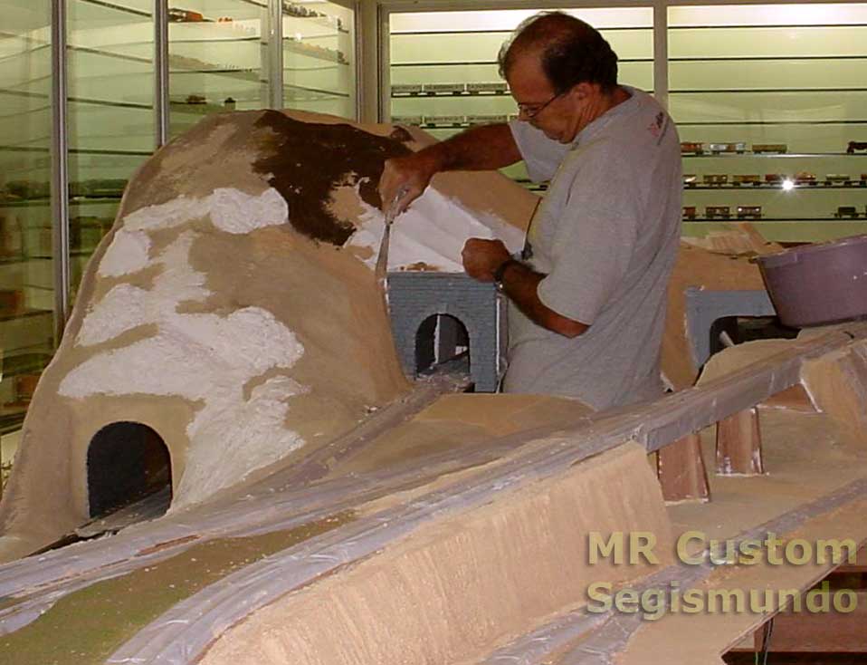 Observe a proteção dos trilhos, na fase de aplicação de gesso, massa corrida, tintas e "grama" na maquete